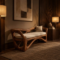 Bench with a sculpted open wooden frame, low arms and a pale cushion in an evening entryway with walnut wall paneling