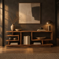 Open shelf console table with stepped square cubbies on a slim plinth in a dark entryway at golden hour