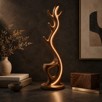 Corner detail of tall floor lamp shaped like an antler with a hollow in the lower body beside wood, brass and linen samples