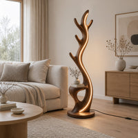 Tall floor lamp shaped like an antler with a hollow in the lower body in a Scandinavian living room with white walls