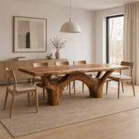 Live edge dining table with arching branch legs under a slab top in a Scandinavian dining room with white walls