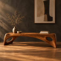 Arched bench with oval cutouts in the end legs in a dark studio against a charcoal plaster wall