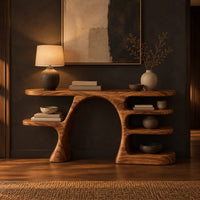 Arched console table with a branch shaped leg and stacked oval shelves in a dark entryway at golden hour