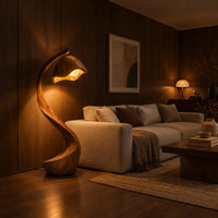 Floor lamp with a long arching wooden stem and a carved hood shade in an evening living room with walnut wall paneling