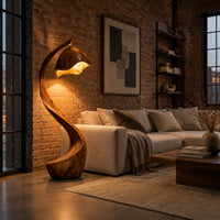Floor lamp with a long arching wooden stem and a carved hood shade in an industrial loft living room with exposed brick