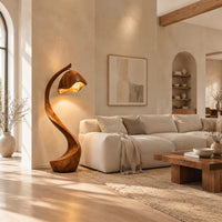 Floor lamp with a long arching wooden stem and a carved hood shade in a bright open plan living room