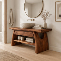 Wood vanity with a thick plank top and arched legs over an open shelf in a Scandinavian bathroom with white walls