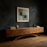 Four door TV cabinet on arched sculpted legs in a dark studio against a charcoal wall