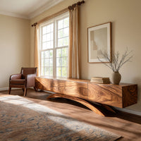 Four door TV cabinet on arched sculpted legs in an open plan space in daylight