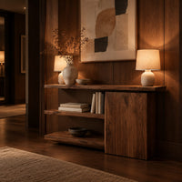 Asymmetric console table with two open shelves beside a closed wood block in an evening entryway with walnut wall paneling