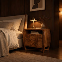 Barrel sided nightstand with an open top cubby and a swirled grain front in an evening bedroom with walnut wall paneling