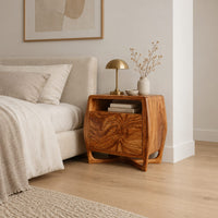 Barrel sided nightstand with an open top cubby and a swirled grain front in a Scandinavian bedroom with white walls