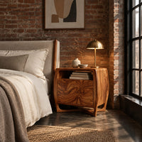 Barrel sided nightstand with an open top cubby and a swirled grain front in an industrial loft bedroom with exposed brick
