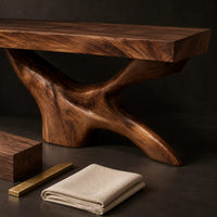 Corner detail of freestanding bathroom vanity with a thick slab top on a carved forked base beside wood, brass and linen samples