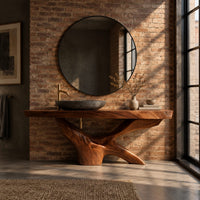 Freestanding bathroom vanity with a thick slab top on a carved forked base in an industrial loft bathroom with exposed brick