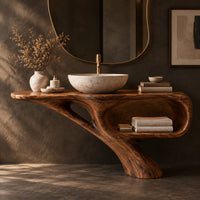 Corner detail of bathroom vanity with a sculpted pedestal foot and an open oval niche beside wood, brass and linen samples