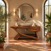 Bathroom vanity with a thick top, single drawer and twisting trunk base in a bright bathroom with arched windows and plants