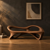 Bench with a flowing frame and large oval openings in a dark studio against a charcoal plaster wall