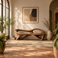 Bench with a flowing frame and large oval openings in a bright entryway with arched windows and plants