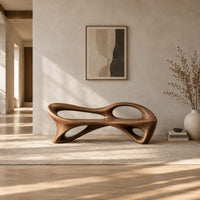 Bench with a flowing frame and large oval openings in a bright open plan entryway