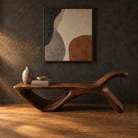 Long flat bench with an open loop base and one raised end in a dark studio against a charcoal plaster wall