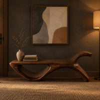 Long flat bench with an open loop base and one raised end in a dark entryway at golden hour