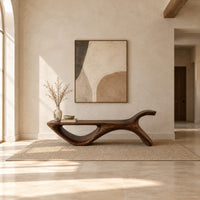 Long flat bench with an open loop base and one raised end in a bright open plan entryway