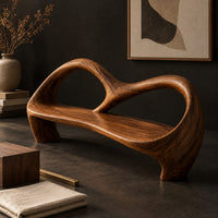 Corner detail of bench with an open looping backrest and sculpted legs beside wood, brass and linen samples