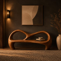 Bench with an open looping backrest and sculpted legs in a dark entryway at golden hour
