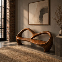 Bench with an open looping backrest and sculpted legs in an industrial loft entryway with exposed brick