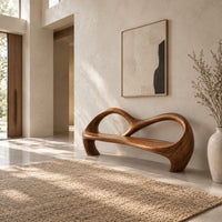 Bench with an open looping backrest and sculpted legs in a bright open plan entryway