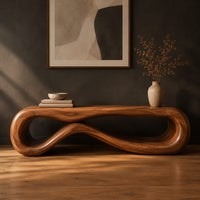 Low wood bench shaped as a figure eight loop with a smooth top in a dark studio against a charcoal plaster wall