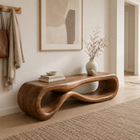 Low wood bench shaped as a figure eight loop with a smooth top in a Scandinavian entryway with white walls