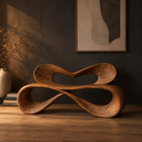 Bench with a heart shaped open back and a folded ribbon seat in a dark studio against a charcoal plaster wall