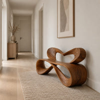 Bench with a heart shaped open back and a folded ribbon seat in a Scandinavian entryway with white walls