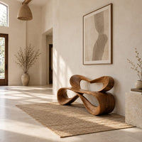 Bench with a heart shaped open back and a folded ribbon seat in a bright open plan entryway