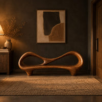Bench with an open loop backrest and sculpted feet in a dark entryway at golden hour