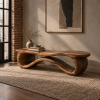 Low wood bench with a wavy slab top on an open ribbon loop base in an industrial loft entryway with exposed brick