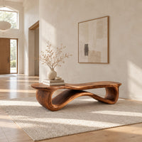 Low wood bench with a wavy slab top on an open ribbon loop base in a bright open plan entryway