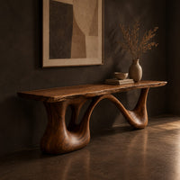 Long low slab bench with a wavy edge on a sculpted base, three-quarter view showing the grain