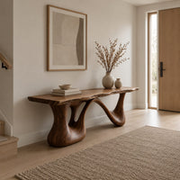 Long low slab bench with a wavy edge on a sculpted base in a Scandinavian entryway with white walls