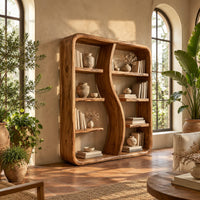 Bookshelf with a wavy s shaped divider and staggered shelves in a bright living room with arched windows and plants