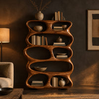 Tall sculpted bookshelf with stacked oval openings of mixed sizes in a dark living room at golden hour