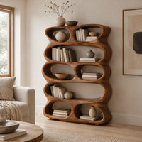 Tall sculpted bookshelf with stacked oval openings of mixed sizes in a Scandinavian living room with white walls
