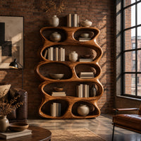 Tall sculpted bookshelf with stacked oval openings of mixed sizes in an industrial loft living room with exposed brick