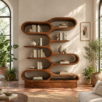 Bookshelf with staggered pill shaped open cubbies above a low base in a bright living room with arched windows and plants