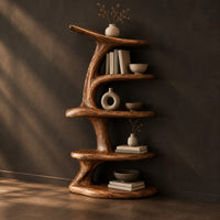Asymmetrical bookshelf shaped like a twisting branch with stacked oval shelves, three-quarter view showing the grain