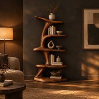 Asymmetrical bookshelf shaped like a twisting branch with stacked oval shelves in a dark living room at golden hour