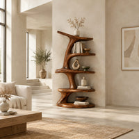 Asymmetrical bookshelf shaped like a twisting branch with stacked oval shelves in a bright open plan living room