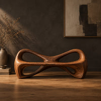 Bow tie bench with two large open loops and a thick smooth frame in a dark studio against a charcoal plaster wall
